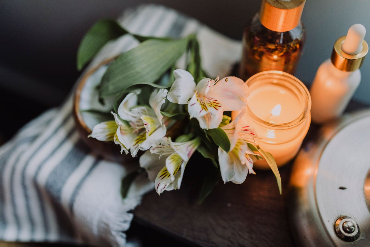 White flowers beside a lit candle, a calming still-life scene