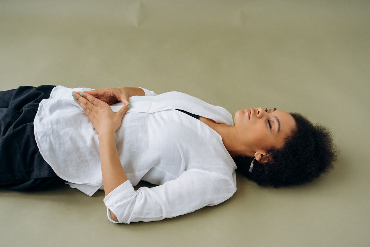 A woman lying down peacefully with eyes closed, embodying calm and rest